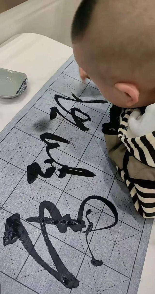 蘇州2歲半寶寶寫字看呆網友，拿石筆在地上寫字乾淨利落，媽媽：家中沒人擅長書法
